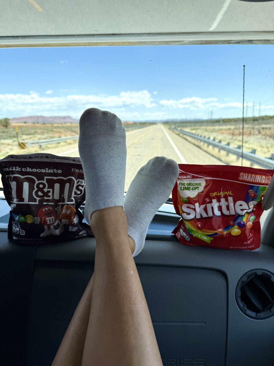 Najlepszy widok z kampera to nie tylko horyzont, ale i słodycze w zasięgu ręki. Kawa z automatu, nogi na desce – to jest życie w wersji „road trip mode on”.