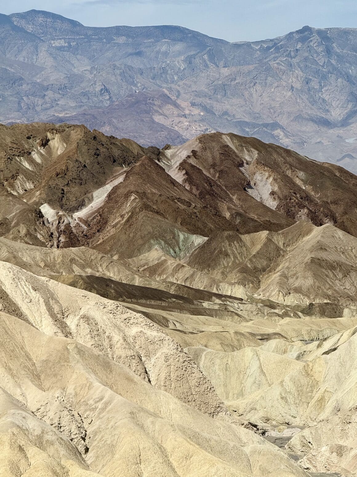 Tu nawet kolory mają gorączkę 🌡️🎨 Te skały wyglądają jakby ktoś wylał na nie całą paletę farb i zostawił na słońcu do „wyschnięcia w 50°C”. Róż, brąz, żółć, mięta — wszystko w idealnym chaosie, którego Photoshop by nie odtworzył. Patrzysz i myślisz: czy to jeszcze Ziemia, czy już folder z gradientami?